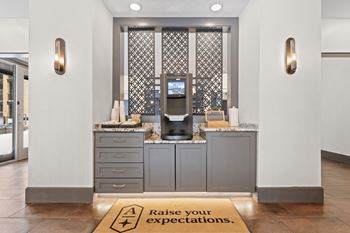 A reception area with a sign that says Raise your expectations at Aster Apartments, Beachwood Ohio